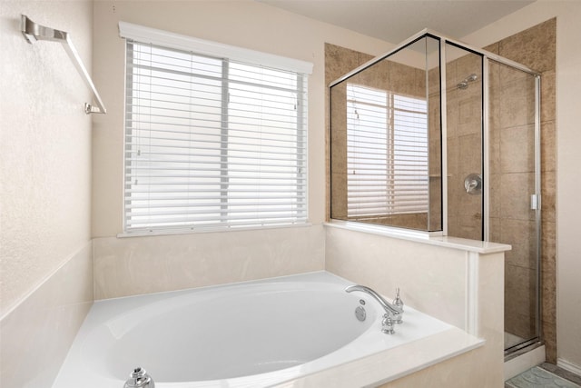 full bathroom with a healthy amount of sunlight, a shower stall, and a garden tub