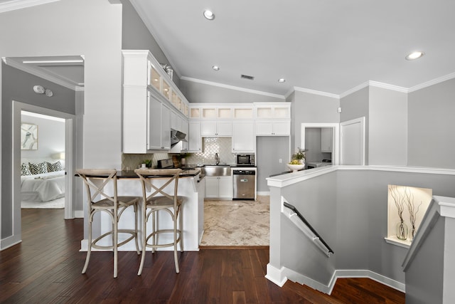 kitchen featuring backsplash, dark wood-style flooring, a peninsula, glass insert cabinets, and stainless steel appliances