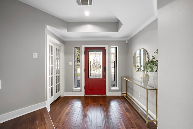 entryway featuring visible vents, crown molding, hardwood / wood-style floors, baseboards, and a raised ceiling