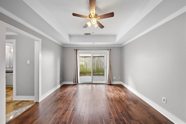 unfurnished room with visible vents, baseboards, dark wood-style floors, a raised ceiling, and a ceiling fan