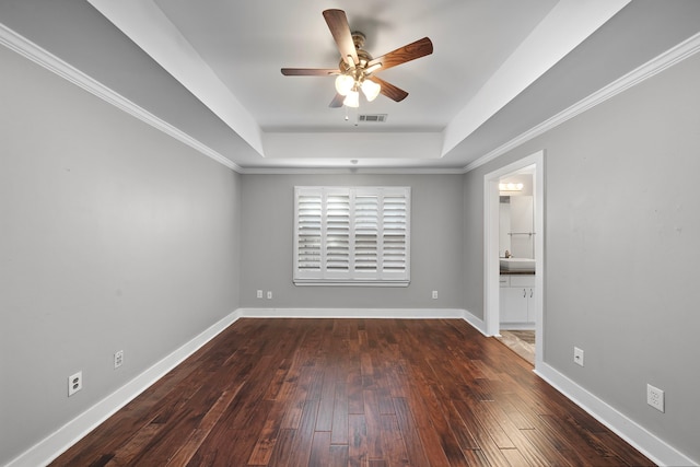 unfurnished room featuring ceiling fan, wood-type flooring, baseboards, a tray ceiling, and visible vents