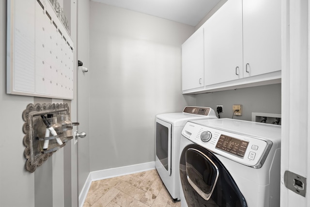 clothes washing area featuring cabinet space, separate washer and dryer, and baseboards