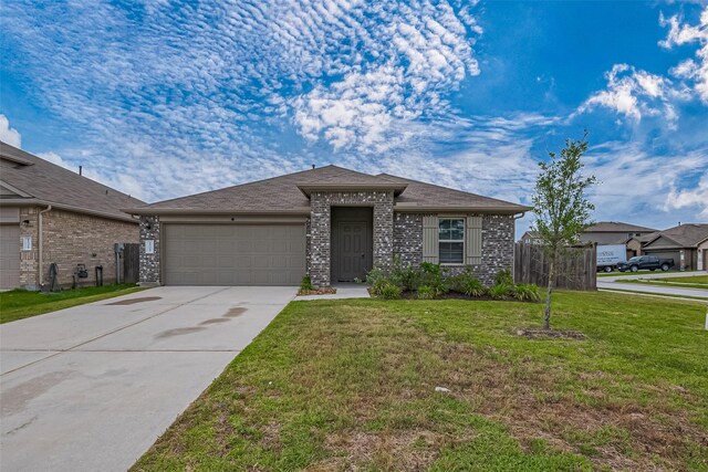 view of front of property with an attached garage, driveway, brick siding, and a front yard
