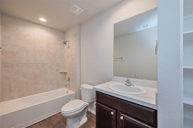 full bathroom featuring vanity, visible vents, wood finished floors, toilet, and shower / bathing tub combination