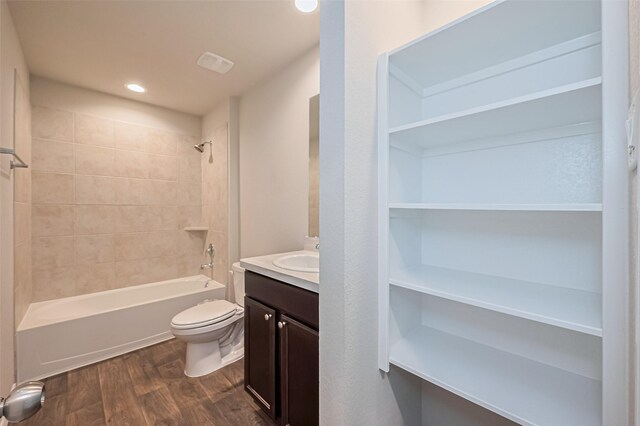 full bath with vanity, wood finished floors, toilet, recessed lighting, and shower / tub combination