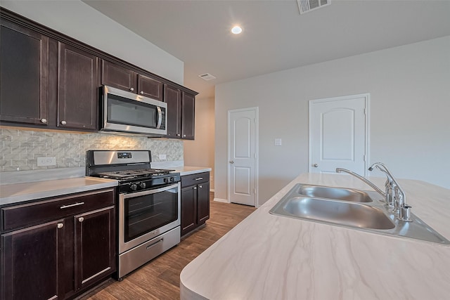 kitchen featuring light countertops, appliances with stainless steel finishes, a sink, and visible vents