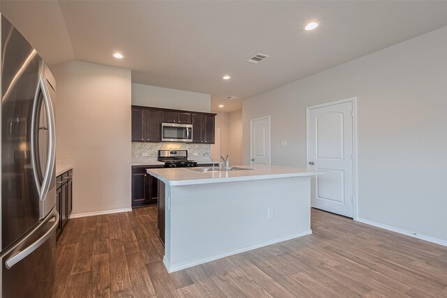 kitchen featuring a sink, light countertops, stainless steel appliances, dark wood-type flooring, and visible vents