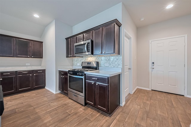 kitchen featuring light countertops, light wood finished floors, appliances with stainless steel finishes, and dark brown cabinetry