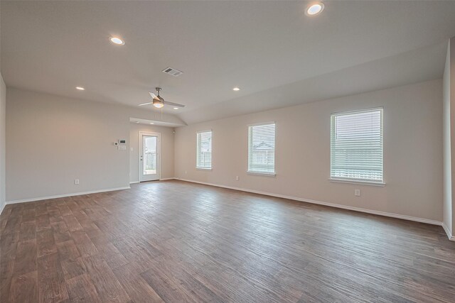 spare room with baseboards, dark wood-type flooring, visible vents, and ceiling fan