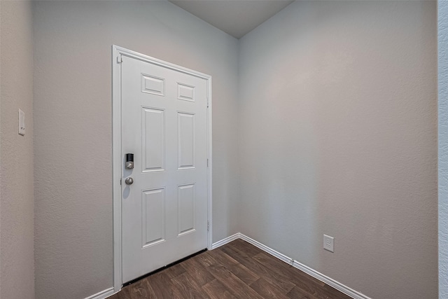 doorway to outside featuring baseboards and dark wood-style flooring