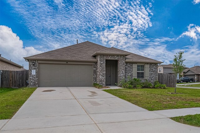 ranch-style home with an attached garage, fence, driveway, and a front lawn