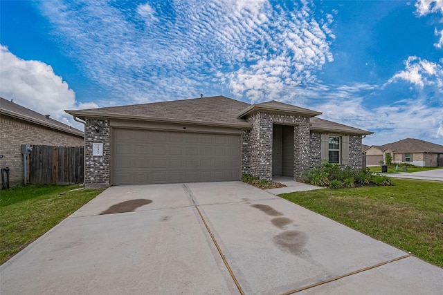 view of front of property with concrete driveway, an attached garage, fence, and a front yard