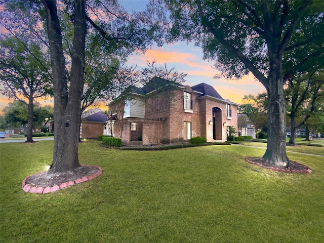 view of front of home with brick siding and a front lawn