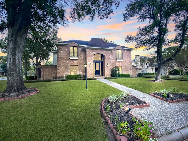view of front facade with a front yard and brick siding