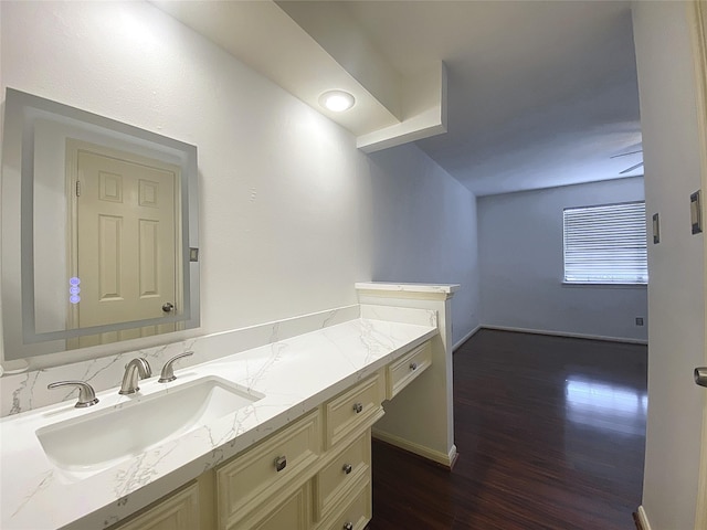 bathroom with baseboards, wood finished floors, and vanity