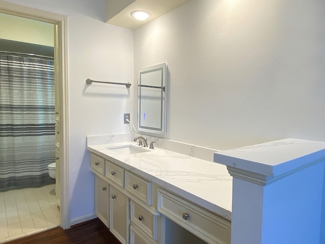 bathroom with vanity, toilet, wood finished floors, and a shower with shower curtain
