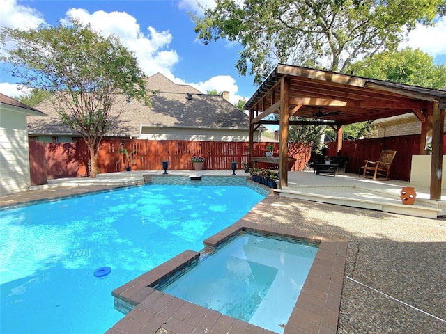 view of pool with a deck, ceiling fan, a pool with connected hot tub, and a fenced backyard