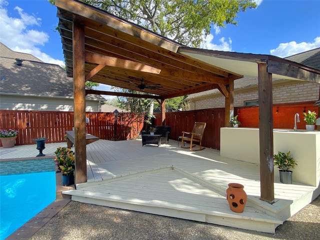 view of patio featuring ceiling fan, fence, and a wooden deck