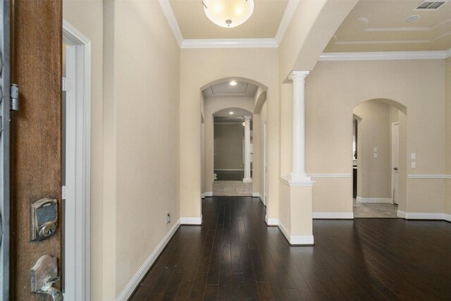 hall featuring crown molding, arched walkways, baseboards, and hardwood / wood-style floors