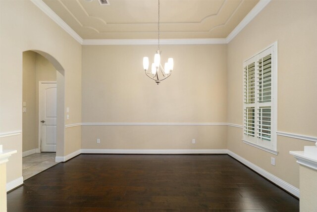 empty room featuring crown molding, arched walkways, wood-type flooring, and a chandelier