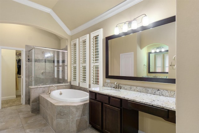 bathroom featuring crown molding, a walk in closet, a bath, a shower stall, and vaulted ceiling