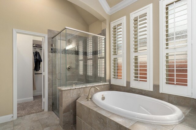 full bathroom with a garden tub, crown molding, a stall shower, baseboards, and a spacious closet
