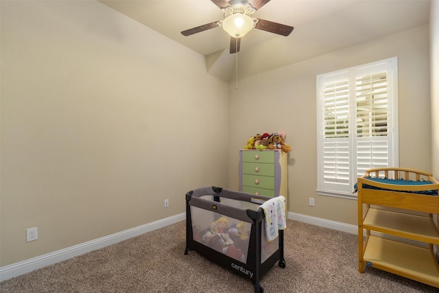 living area featuring baseboards, ceiling fan, and carpet