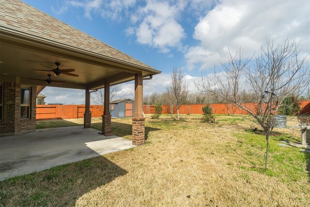 view of yard featuring a fenced backyard, a patio, ceiling fan, and a shed