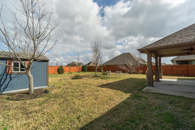 view of yard with a patio, a fenced backyard, a storage shed, and an outdoor structure
