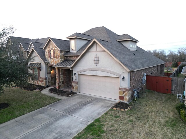 view of front of property with roof with shingles, stone siding, driveway, and a front yard