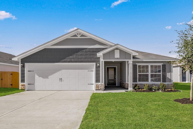 view of front facade with a garage, concrete driveway, a front lawn, and stone siding
