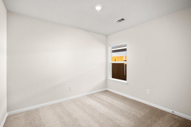 empty room featuring baseboards, carpet floors, and visible vents