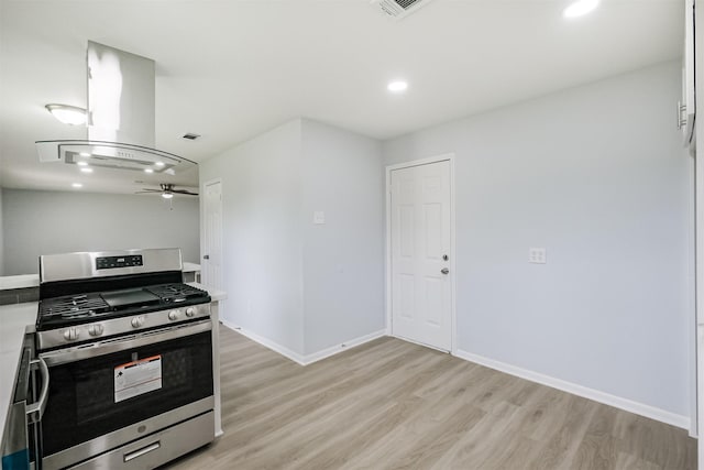 4314 Woodmont Dr, Houston, TX 77045 - kitchen with ceiling fan, island range hood, stainless steel gas range oven, light wood-type flooring, and recessed lighting
