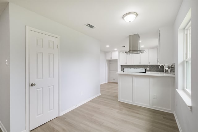 4314 Woodmont Dr, Houston, TX 77045 - kitchen with decorative backsplash, light wood-type flooring, island exhaust hood, and visible vents