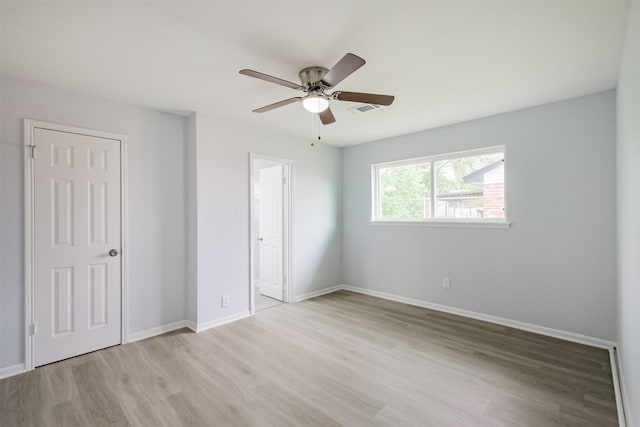 4314 Woodmont Dr, Houston, TX 77045 - unfurnished bedroom with visible vents, light wood-style floors, baseboards, a ceiling fan, and ensuite bath