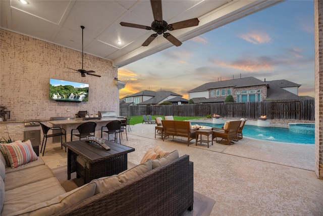view of patio / terrace featuring a fenced backyard, ceiling fan, an outdoor living space, and a bar