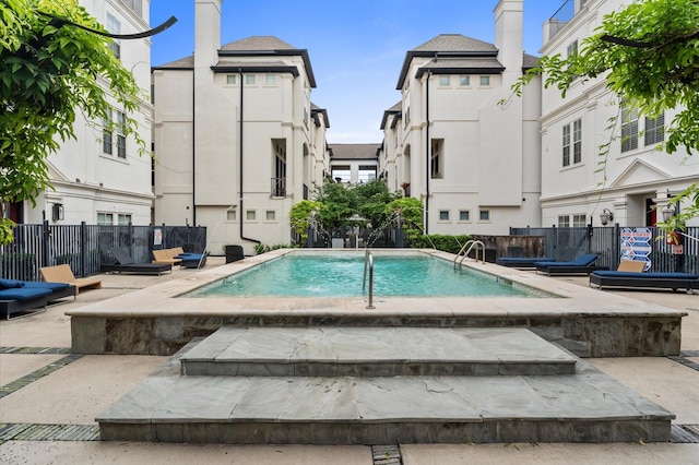 pool with fence, a patio area, and a residential view