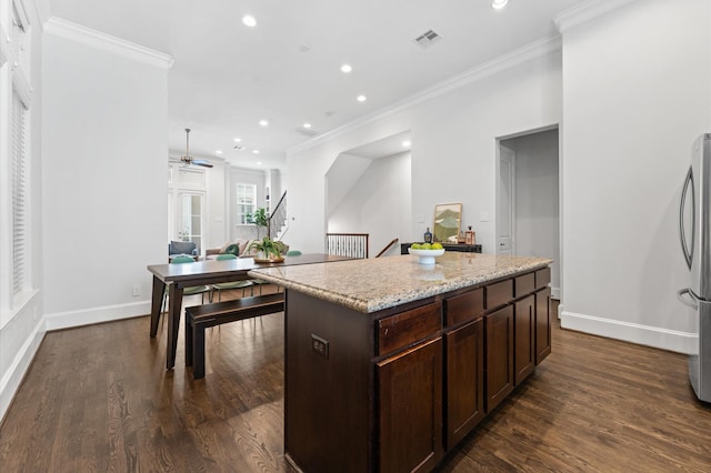 kitchen with recessed lighting, ornamental molding, and freestanding refrigerator