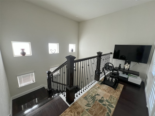 stairs featuring baseboards, plenty of natural light, and wood finished floors