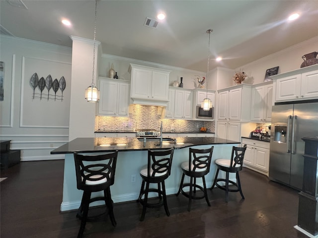 kitchen with decorative backsplash, visible vents, dark countertops, appliances with stainless steel finishes, and a sink