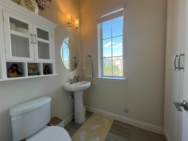 bathroom featuring a sink, baseboards, and toilet