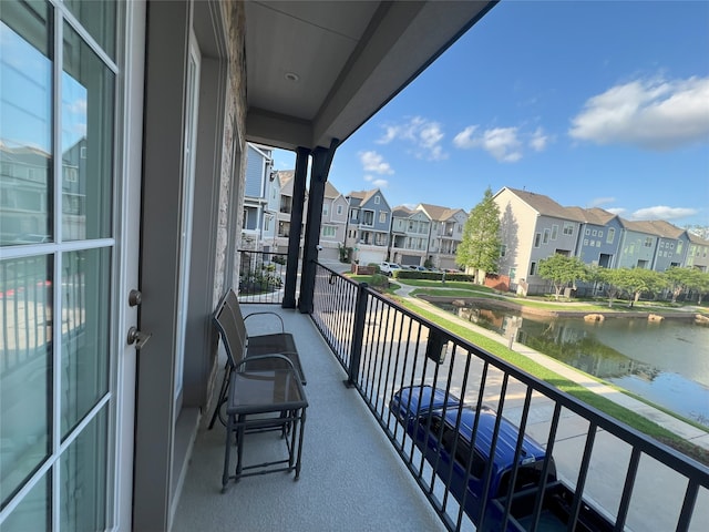 balcony featuring a water view and a residential view