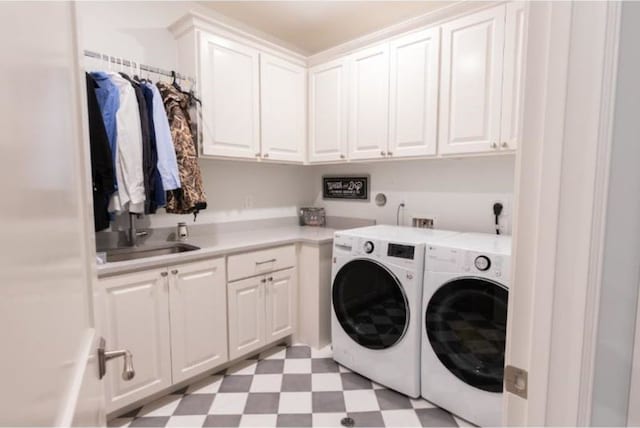 laundry area featuring cabinet space, separate washer and dryer, a sink, and light floors