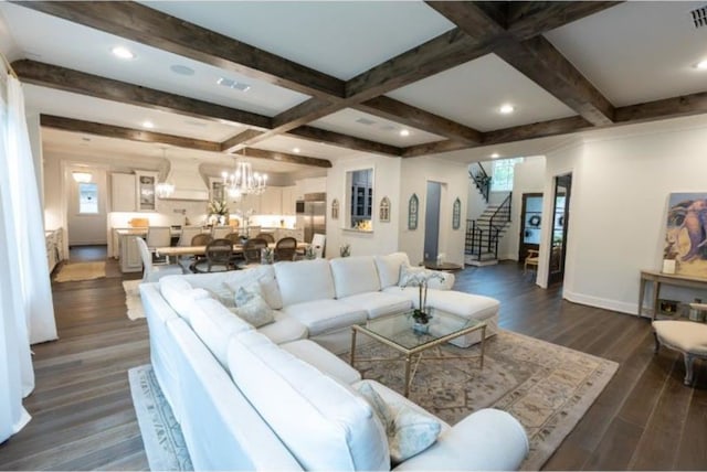 living area with visible vents, stairway, baseboards, beamed ceiling, and a notable chandelier