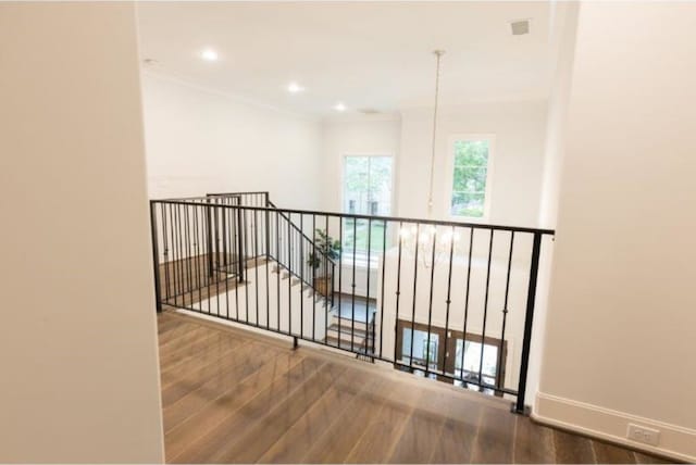 interior space with visible vents, wood finished floors, baseboards, ornamental molding, and recessed lighting