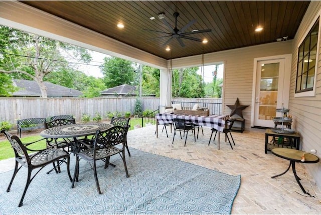 view of patio with a ceiling fan, outdoor dining space, and a fenced backyard