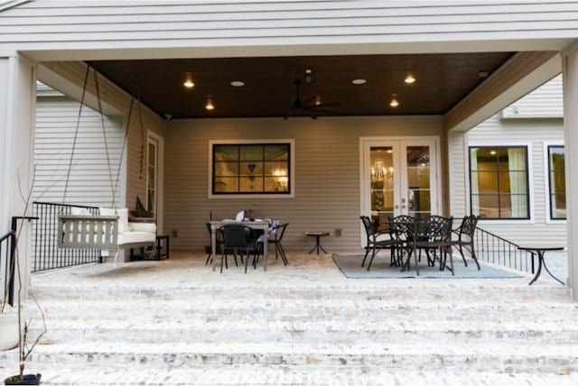 deck featuring outdoor dining area, ceiling fan, french doors, and a patio