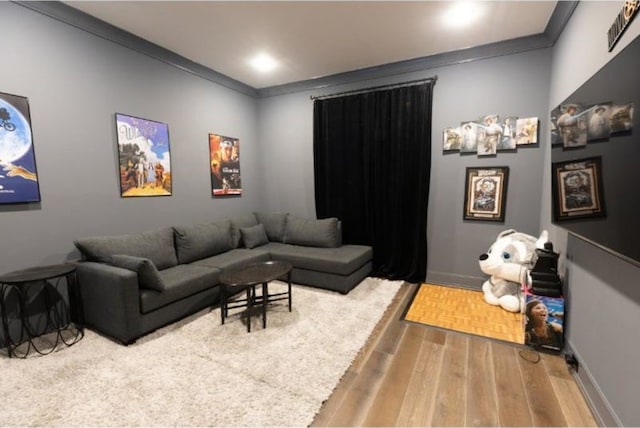 living room with crown molding, baseboards, and wood finished floors