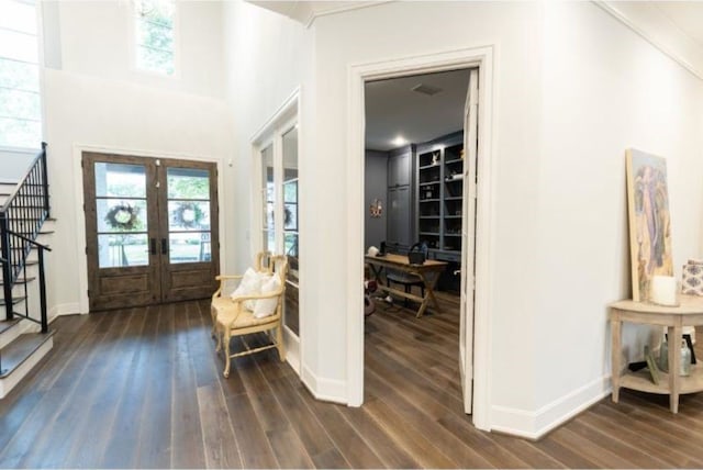 foyer entrance with stairway, baseboards, french doors, and dark wood-type flooring