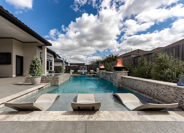 view of swimming pool featuring a fenced backyard, a pool with connected hot tub, and a patio area